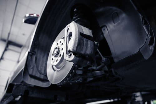 Closeup of steel brake disc in car service.