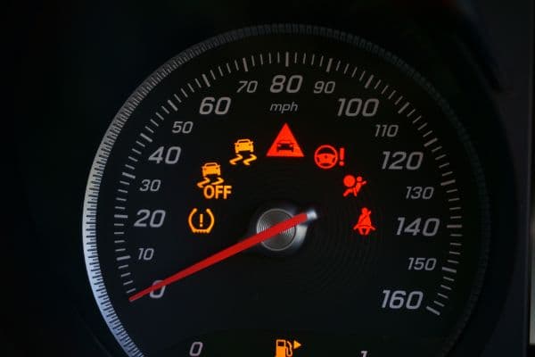 Close up of speedometer dial with warning lights on a car